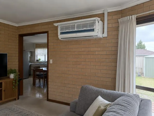Open split system head on a brick living room wall with filters visible above a doorway in Elizabeth Downs